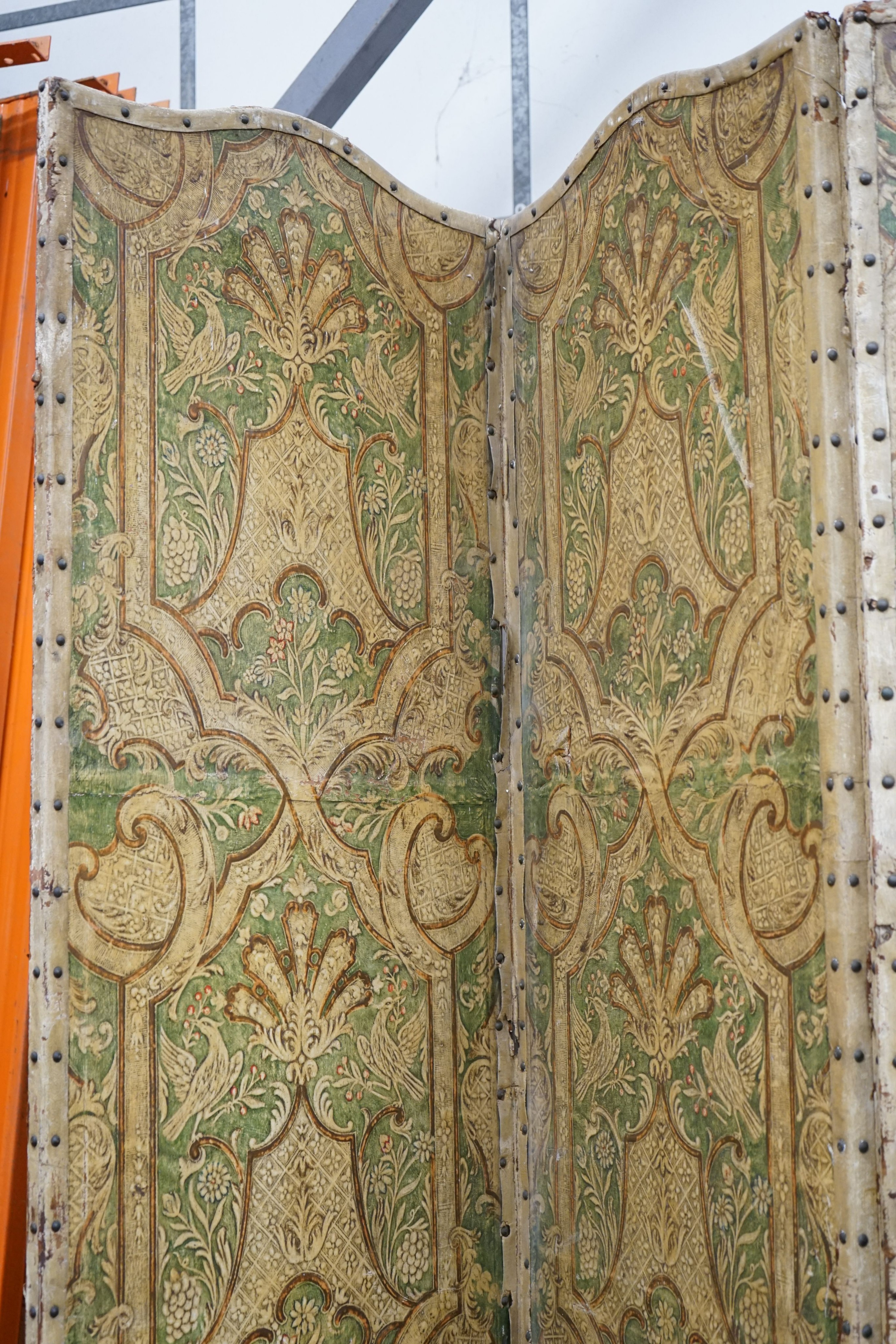 A Spanish painted leather three fold dressing screen, each panel width 60cm, height 237cm